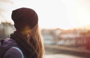 A homeless girl looking at the horizon.