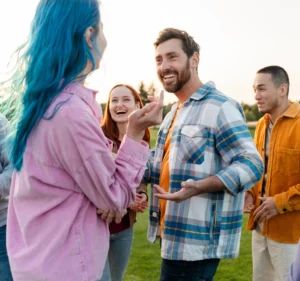 An adult interacting with several teenaged youth outside. This image is being used for PolicyWise's news story "Turing strategy into action."