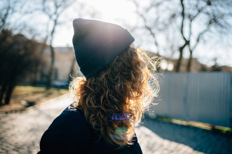 Image of a young woman outside wearing a toque. This image is being used for PolicyWise for Children & Families' news story "Strengthening service access through responsible data sharing for youth homelessness services."