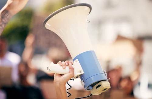 A close-up of a megaphone being held in the air. This image is being used by PolicyWise for Children & Families for their news story "Leading the shift from evidence to impact."