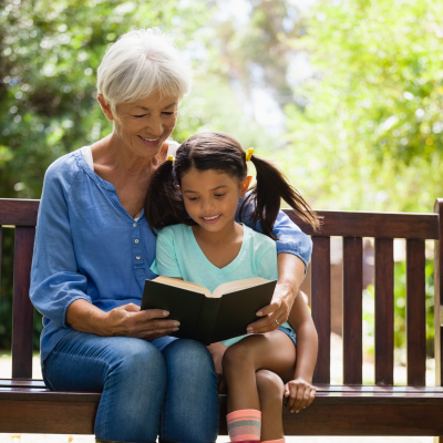 generating and sharing knowledge - A child and elder sitting reading a book